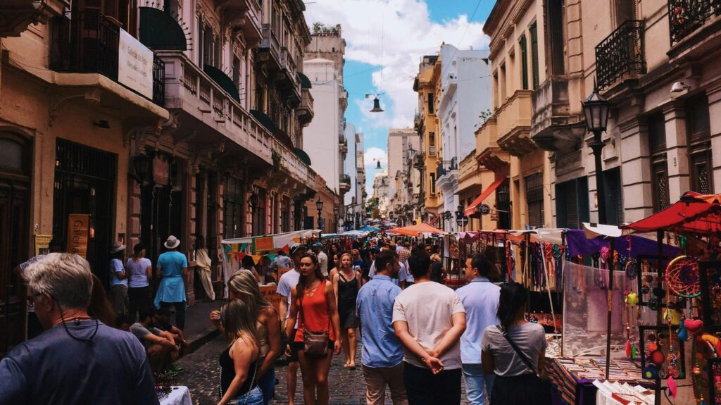Bustling San Nicolas street market in Buenos Aires with stalls and crowds under a clear sky.